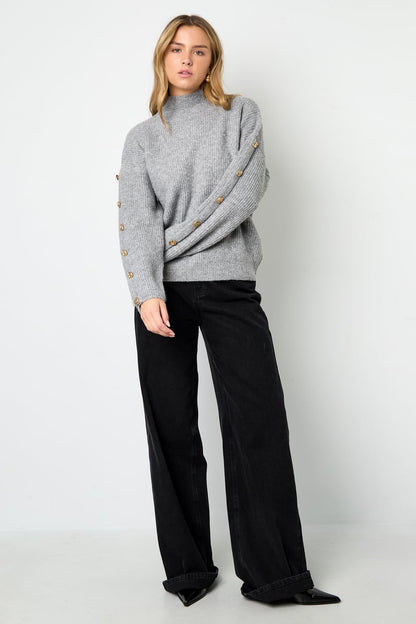 Trui met knopen op de mouwen